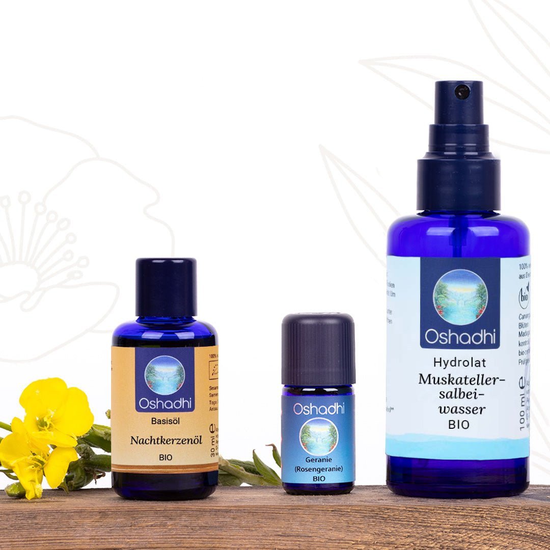 Set mit Basisöl, ätherischem Öl und Hydrolat im Vordergrund und links gelbe Blume